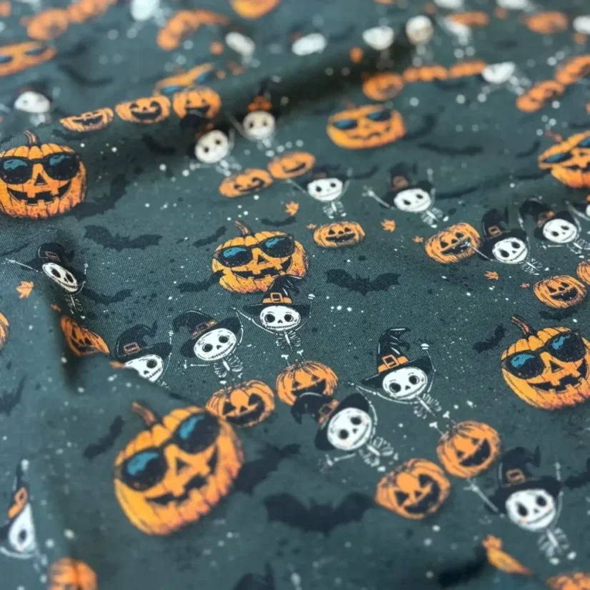Detail halloweenské látky s motivem dýní a veselých kostlivců