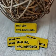 Koženkový štítek Nový den, nová lumpárna ve žluté barvě – detail produktu.