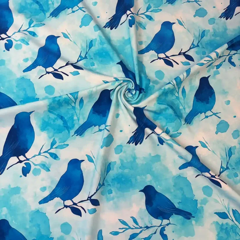 Látka na šití s motivem ptáčků v modrých tónech na světle modrém podkladu