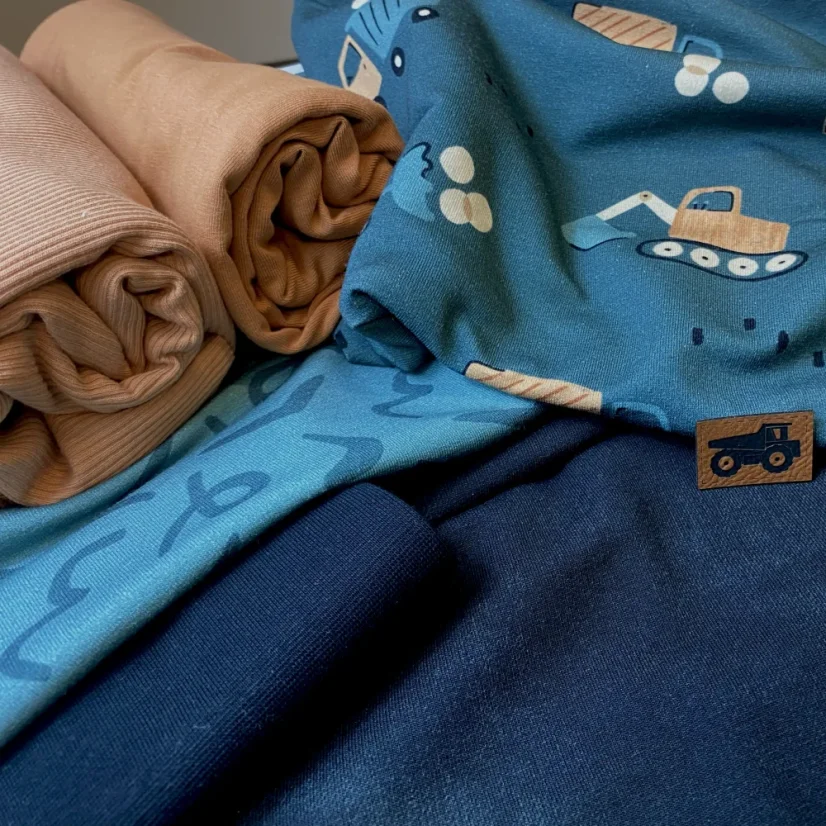 Balíček dětských látek se stavebními stroji a jednobarevnými teplákovinami