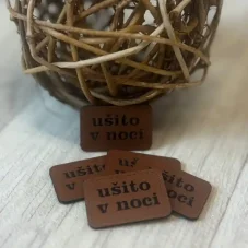 Koženkový štítek s nápisem ušito v noci v kávové barvě