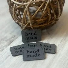 Šedý koženkový štítek s nápisem handmade