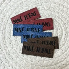 Koženkové štítky s nápisem „Mně jebne“ v červené, modré a hnědé barvě