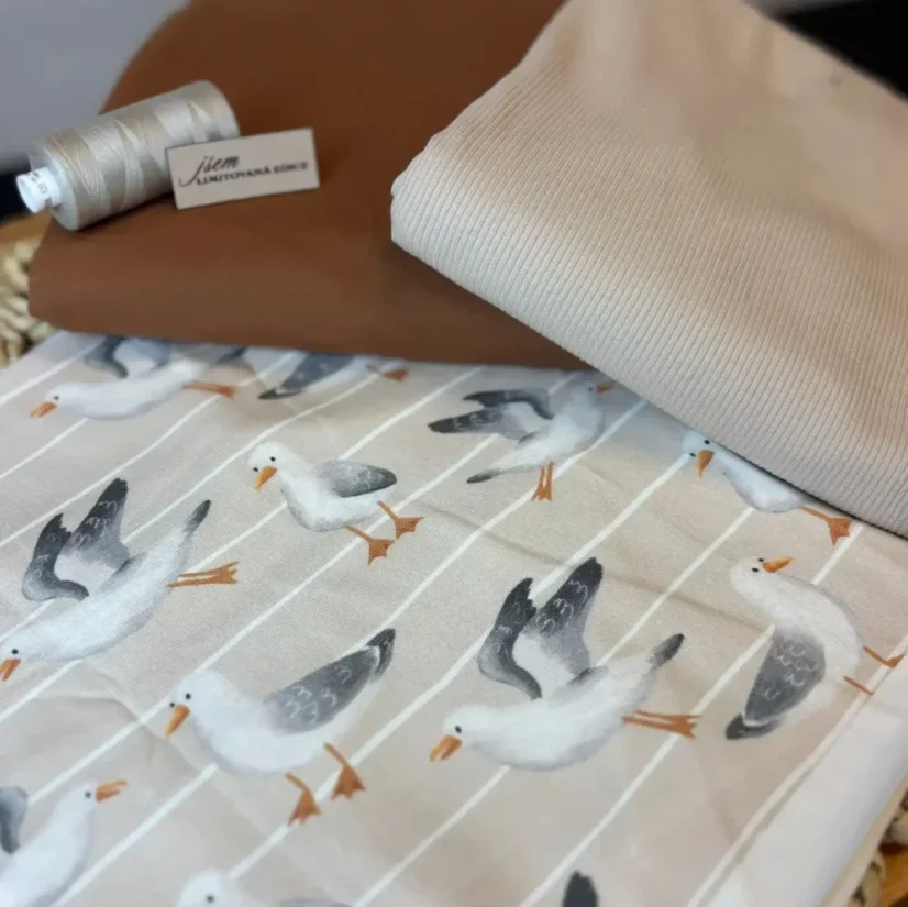 Námořnicky laděný balíček s potiskem racků, úpletem v teplé hnědé a světle béžové barvě, doplněný o nit a štítek „jsem limitovaná edice“.