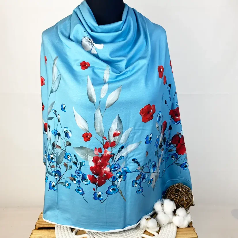 Modrý panel bavlněného úpletu aranžovaný na figuríně s akvarelovými červenými vlčími máky a drobnými modrými květy.