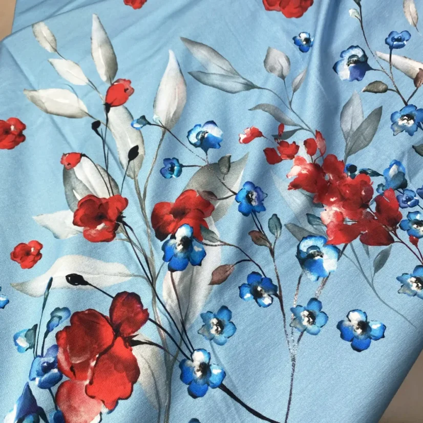 Modrý panel bavlněného úpletu s akvarelovými červenými vlčími máky a drobnými modrými květy.