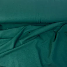 Detail tmavě zeleného bio organického single-jersey úpletu s jemnou hladkou strukturou.